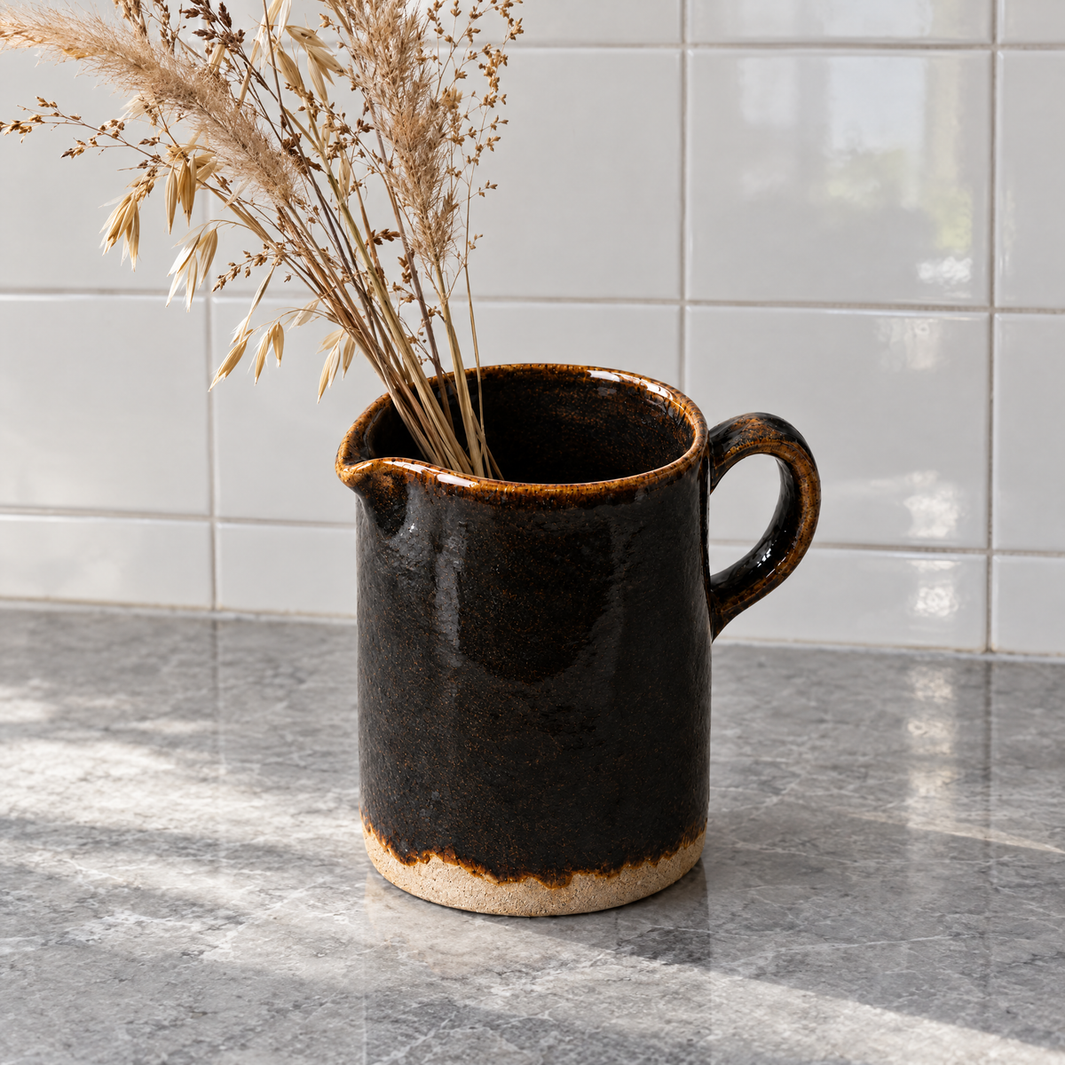 Pour Jug in Iron holding dried grasses on a marble counter